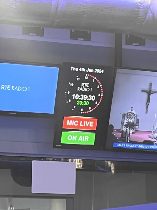 Three screens in a broadcast room. One shows the RTÉ Radio 1 logo, one shows a clock with 20mins 30s remaining on Jan 4th. The final screen shows Mass on RTE (TV) 1.