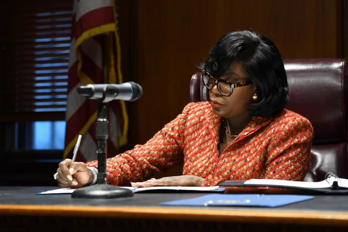 Mayor Cherelle Parker sitting at a desk signing an executive order.