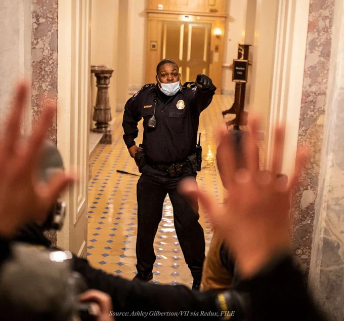 U.S. Capitol Police Officer Eugene Goodman confronts protesters as they storm the Capitol in Washington, D.C.

Text below that reads: 
Source: Ashley Gilbertson/VII via Redux, FILE