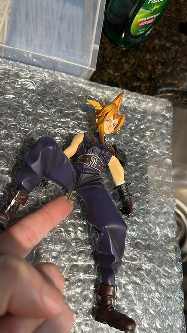 Cloud Strife statue from Final Fantasy 7 with a support peg placed in between the legs