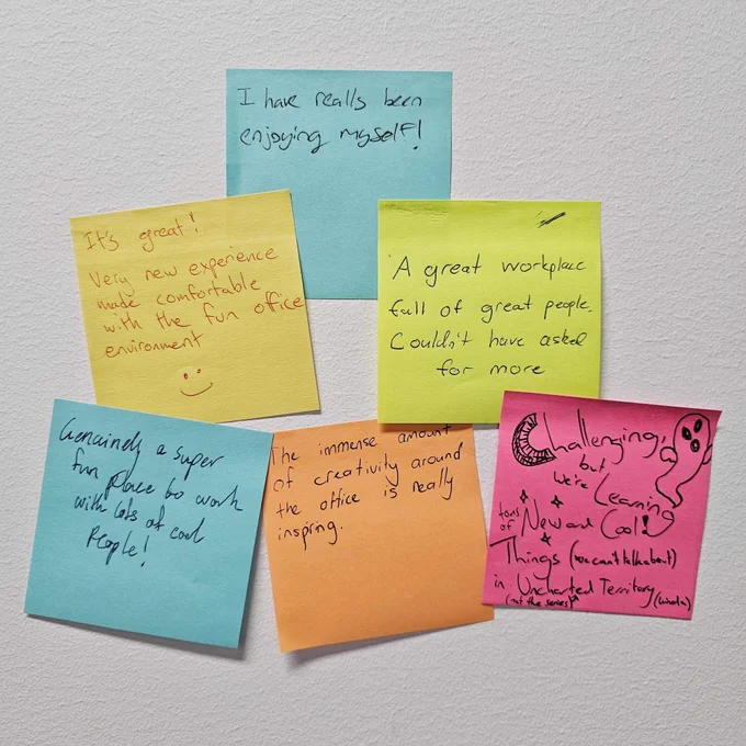 Group of post-it notes stuck to a wall, reading: 1 “I have really been enjoying myself!”, 2 “It’s great! Very new experience made comfortable with the fun office environment 🙂”, 3 “A great workplace full of great people. Couldn’t have asked for more”, 4 “Genuinely a super fun place to work with lots of cool people!”, 5 “The immense amount of creativity around the office is really inspiring.”, and 6 “Challenging, but we’re learning tons of new and Cool! Things (we can’t talk about) in Uncharted (not the series) Territory (kinda)”.