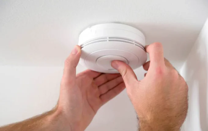 Smoke alarm being fitted