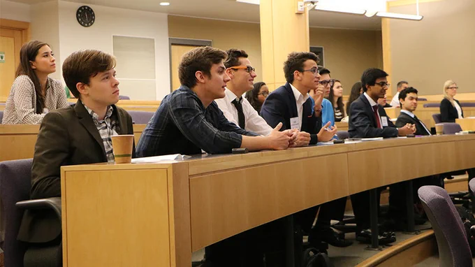 Group of people sitting at desks in a lecture hall