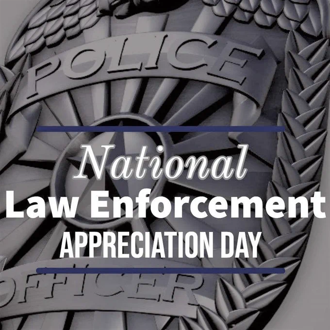 A close-up of a police badge in grey tones, with the TEXT: National Law Enforcement Appreciation Day