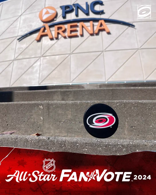Photo of a puck on the stairs of the exterior of PNC Arena with the PNC Arena logo in the background. There is also text on the bottom of the photo featuring the All-Star Fan Vote logo