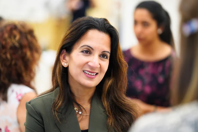 Dr. Svati Shah smiling and talking with someone in a crowded room at the North Carolina Research Campus in Kannapolis. 