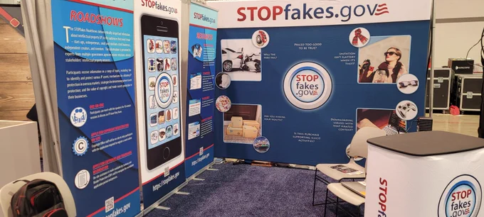STOPfakes booth at the CES conference. Features blue and white banners with text about STOPfakes.