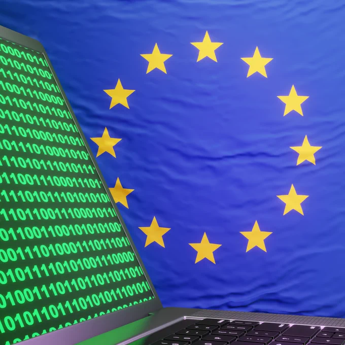 Silver laptop showing computer binary code on European Union flag. Illustration of the concept of EU computer misuse act and cybercrime