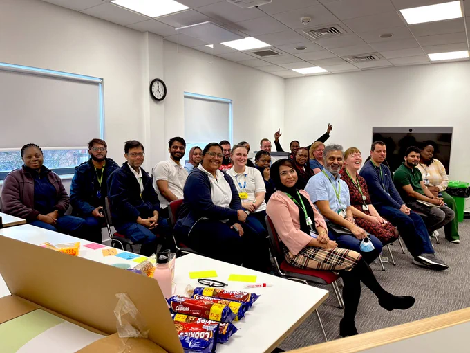 Group of 20 people sitting together and smiling