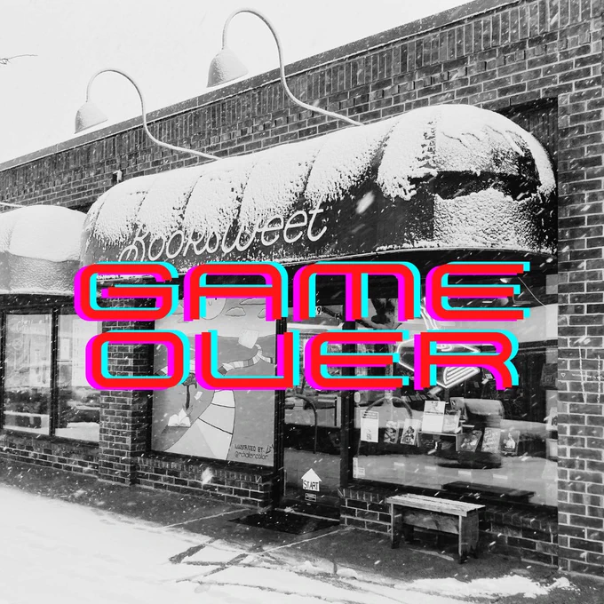 Black and white image of the shop covered in snow. Text: Game Over.