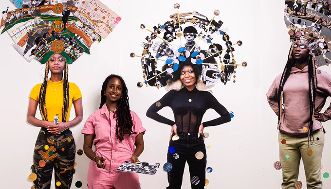Artist Helina Metaferia holding a tray with acrylic paint and a brush in front of her work depicting black women with cutouts of images pasted above their heads.