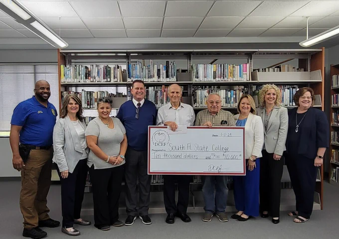Group with donation check at the DeSoto Campus
