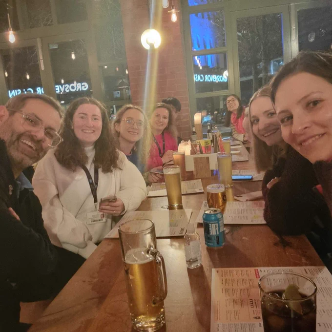 Group of people sat round a table in a restaurant smiling