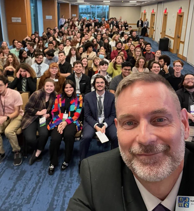 James Daugherty selfie with roomful of Florida NAfME Collegiate members seated in background