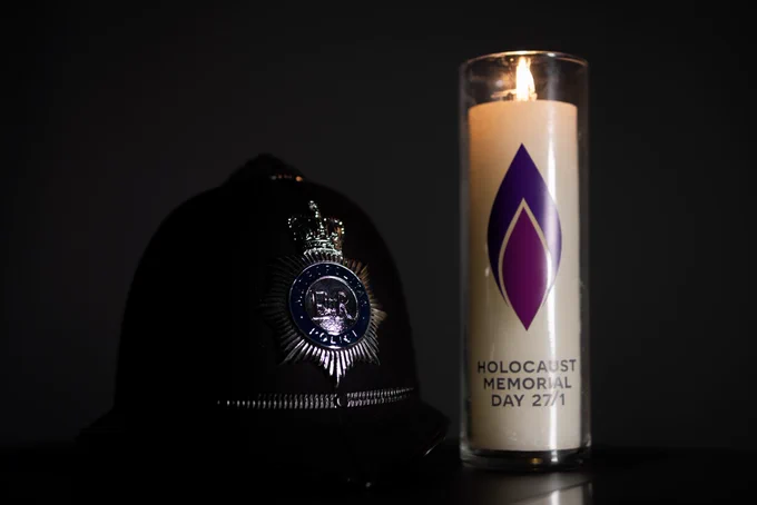 A photograph of a Metropolitan Police officer’s helmet next to a candle commemorating Holocaust Memorial Day.