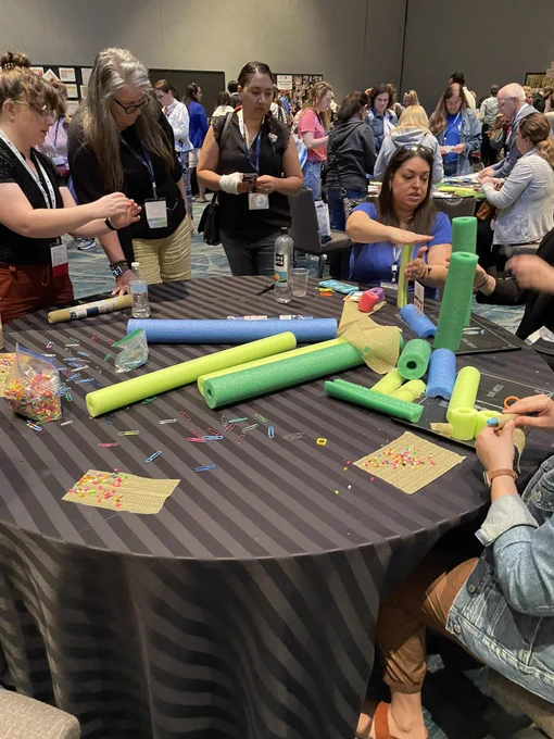 People sitting at a table cutting pool noodles