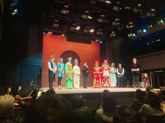 Performers onstage in a mix of traditional and modern Cantonese outfits.