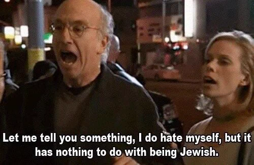 Image: Screenshot from the show Curb Your Enthusiasm with Larry David saying "Let me tell you something, I do hate myself, but it has nothing to do with being Jewish." Video still of an older white man, wearing glasses, and a white woman.
