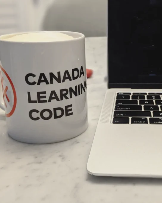 Photo of CLC branded mug and open laptop 