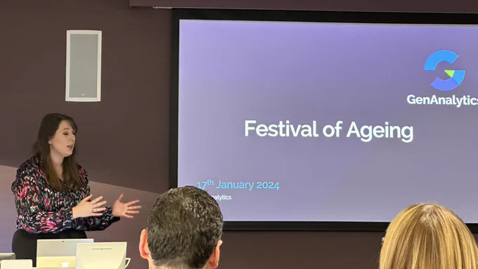 Minister Emma Roddick MSP speaks at the front of a conference screen. The screen says Festival of Ageing.