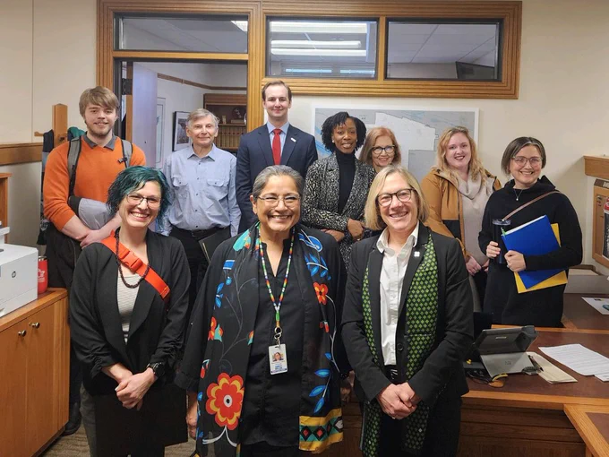 A group of adults pose together in an office space