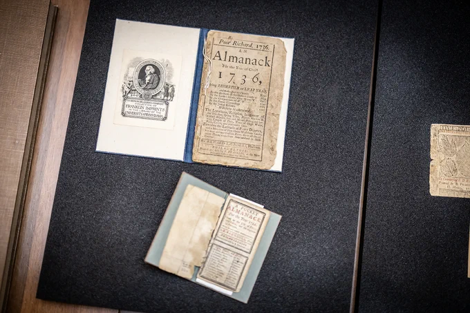 Two copies of Poor Richard's Almanac laying open on a table.