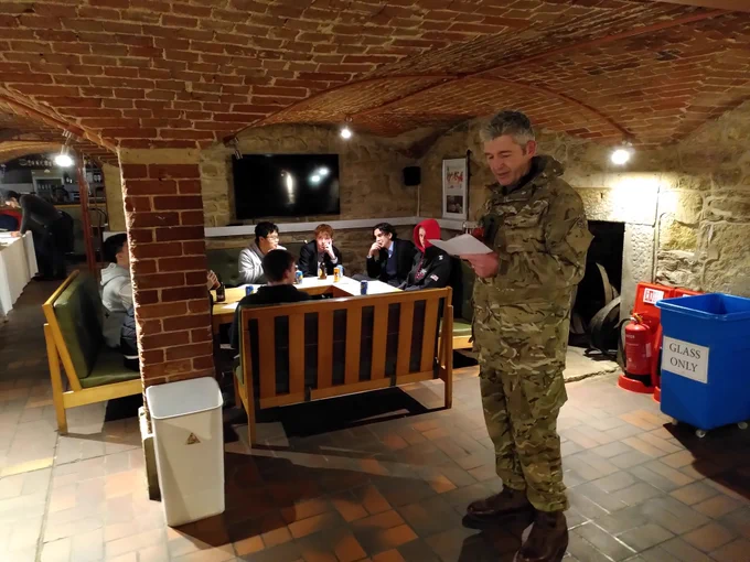 A teacher in camo reading out answers to quiz