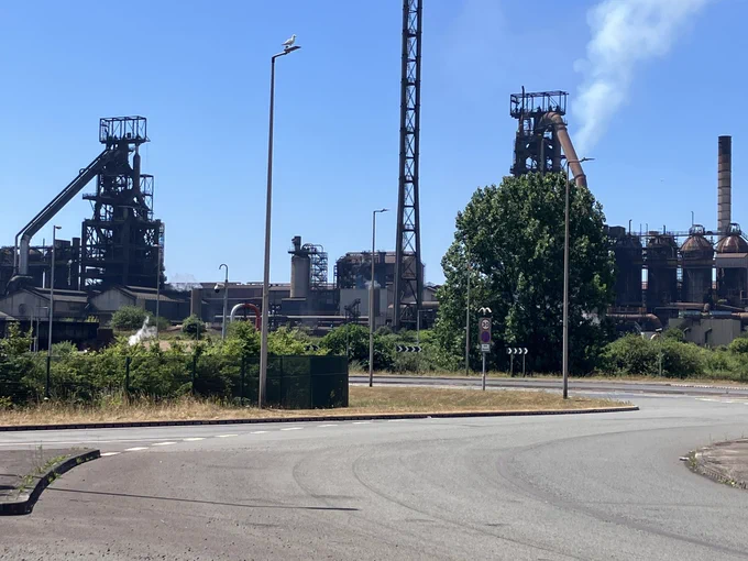 Two blast furnaces with Cowper stoves at Port Talbot, Wales, and a roundabout. Steam rises from one of them.