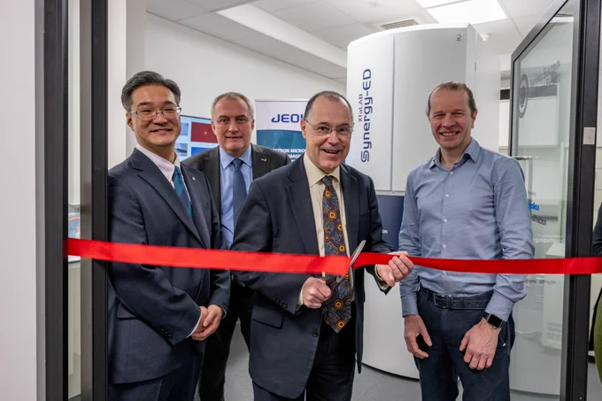 Vice-Chancellor Mark E Smith cuts a red ribbon in front of the Electron Diffraction Facility. Hiroyuki Kanda, Global Product Leader of Life Science, Shaun Quill MD of Jeol and Simon Coles, UoS Professor of Structural Chemistry and Director, UK National Crystallography Service stand next to him smiling.