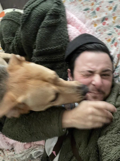 Blurry picture of me laying down and my dog licking my face