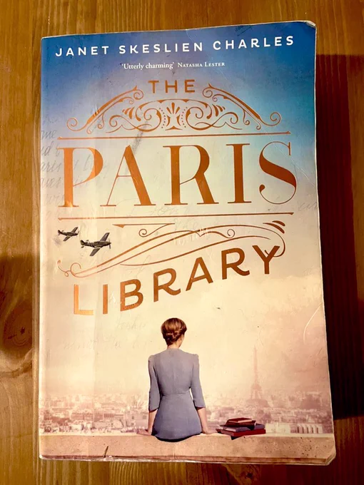 The book the Paris library on a wooden table