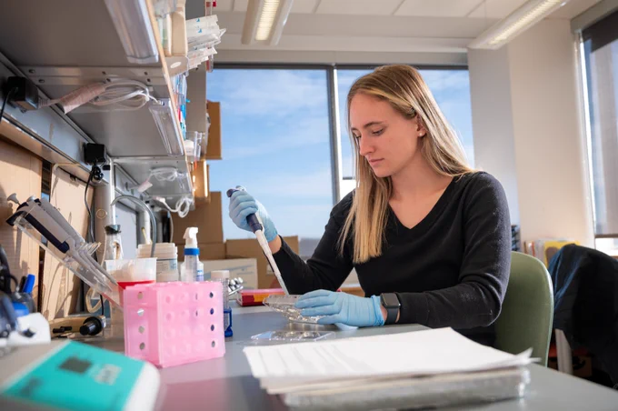 Mia Carrarini uses a pipette in the lab.