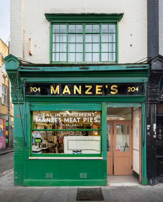 A photograph of a green pie shop with the name 'Manze's'