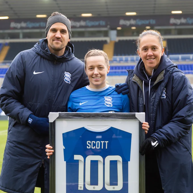 Harriet Scott pictured with a framed shirt alongside Head Coach, Darren Carter, and former Assistant Head Coach, Jo Potter. 