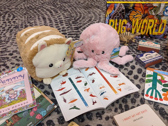 Coco the cat loaf and Olive the octopus reading a book together