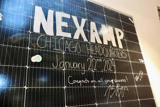 A sign that reads, “Nexamp Chicago Headquaters” with Governor Pritzker’s signature and message of “Congrats on all your success!”