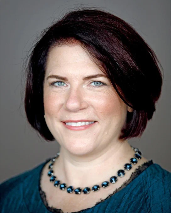 A headshot of a person smiling.