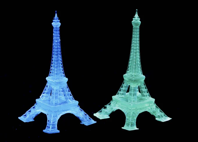 From left: Blue and green Eiffel Tower-shaped luminescent structures 3D-printed from supramolecular ink