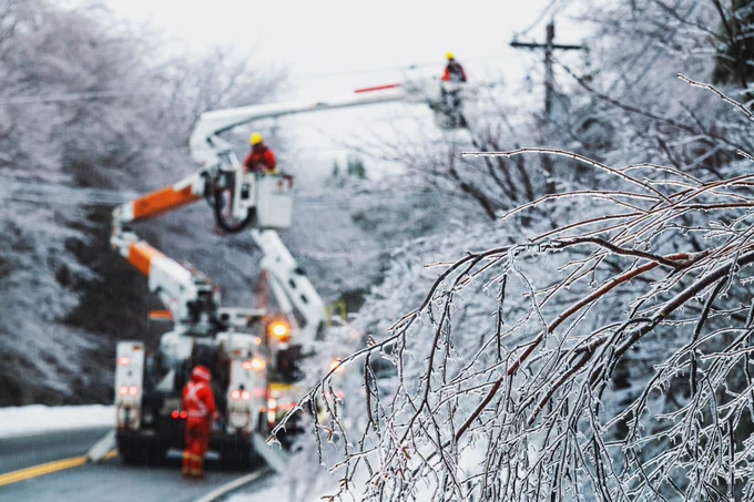 electrical crews working on a line in an ice storm