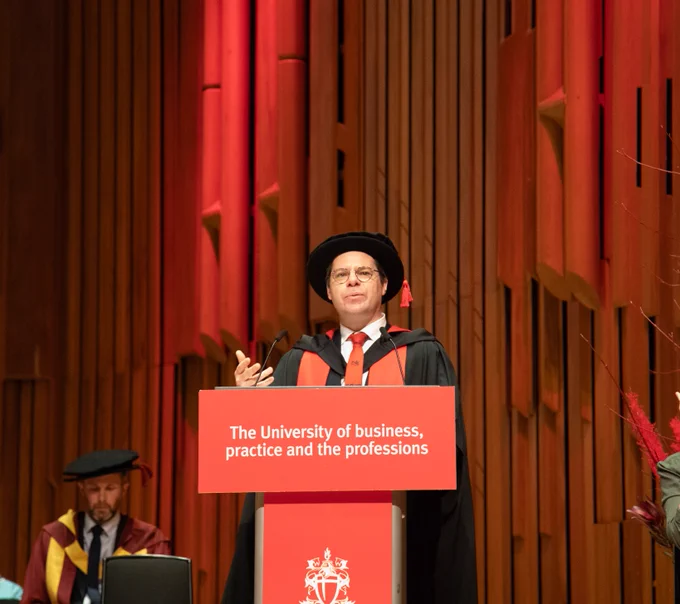 Photo of Bayes dean on stage 