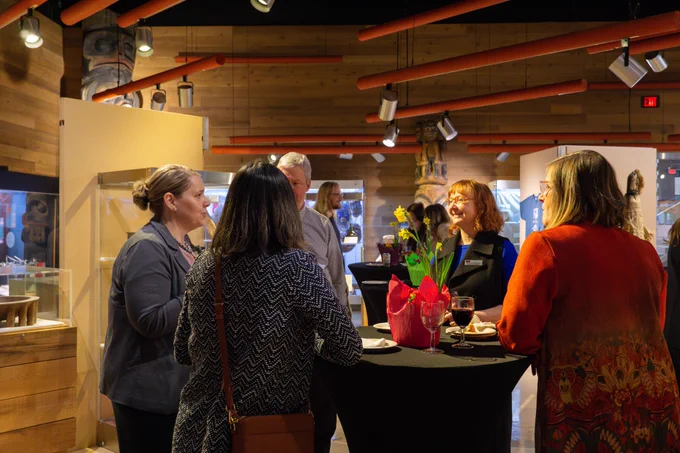 A group of SFU researchers, including AVPR pro tem Valorie Crooks and Dean of Science Angela Brooks-Wilson, are gathered around a table. They look to be deep in conversation.