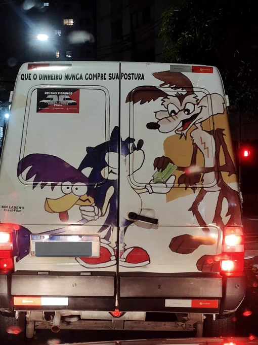 Uma van branca na rua, à noite. Há um desenho nele de qualidade questionável onde o coiote entrega o que parece ser um bolo de notas ao Sonic, que segura o papaléguas pelo pescoço. No canto superior esquerdo há uma mensagem: que o dinheiro nunca compre sua postura