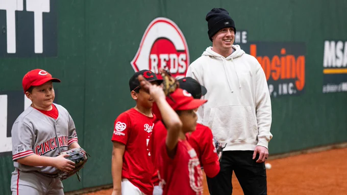 Jacob Hurtubise smiles while looking on at drills at the Reds Youth Academy.