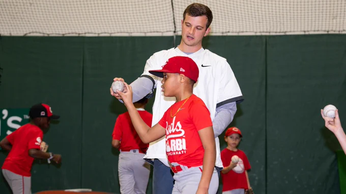 Carson Spiers teaching how to grip a pitch at the Reds Youth Academy. 