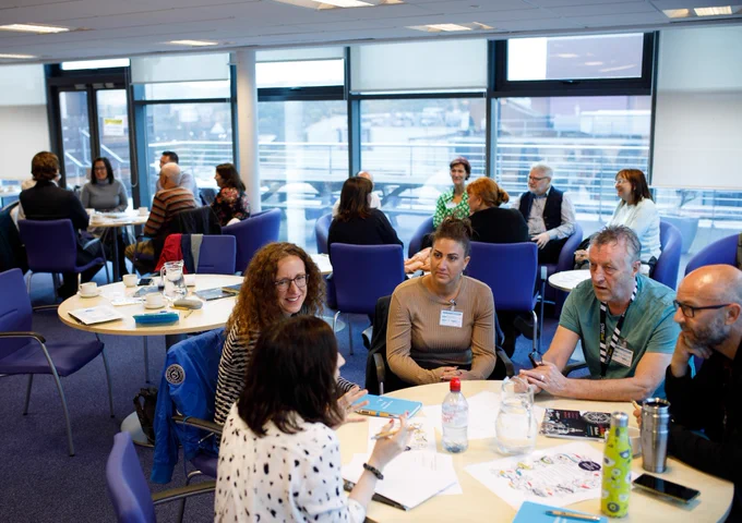Adult learners and practitioners engaged in a conversation at a Northern Ireland adult education event.