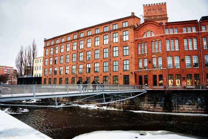 Vy mot Kåkenhus och gångbro över Motala ström på Campus Norrköping.