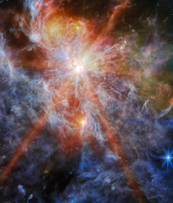 Image description: A bright young star within a colourful nebula. The star is identifiable as the brightest spot in the image, surrounded by six large spokes of light that cross the image. A number of other bright spots can also be seen in the clouds, which are shown in great detail as layers of colourful wisps.
This image includes 7.7-micron light shown in blue, 10 microns in cyan, 15 microns in yellow, and 21 microns in red (770W, 1000W, 1500W, and 2100W filters, respectively).