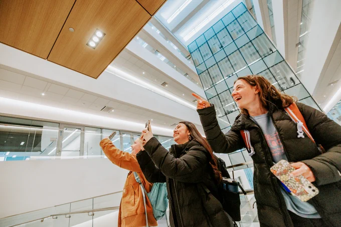 Civil Engineering sophomores, from left, Meghan Murphy, Fatima Pilar-Solis, and Miriam Huss photograph friends as they go to their first class in Kiewit Hall.