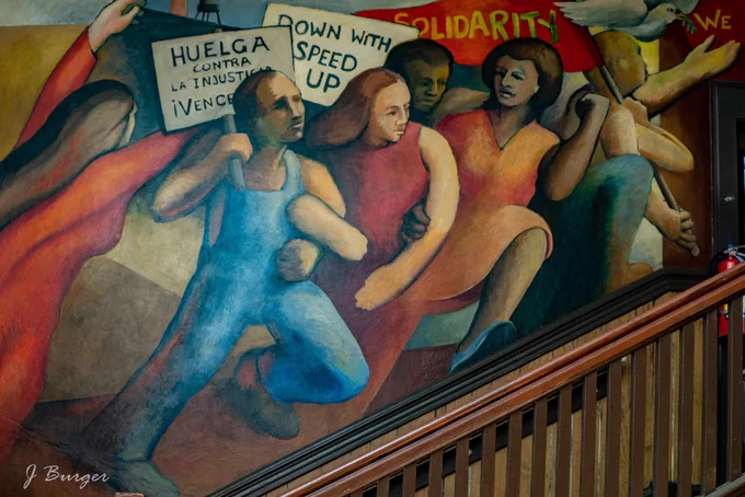 Part of the mural of workers holding picket signs