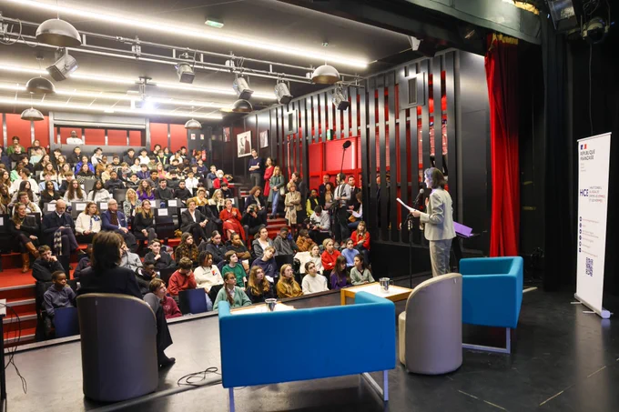 Vue large de l'amphithéâtre. Amélie Oudéa-Castéra, debout, s'exprime devant l'auditoire.